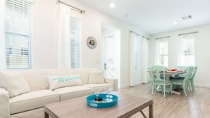 Una sala de estar con un sofá, una mesa de centro y un comedor con una mesa y sillas.