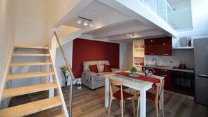 En moderne lejlighed med trappe, spiseplads, køkken og opholdsstue.
