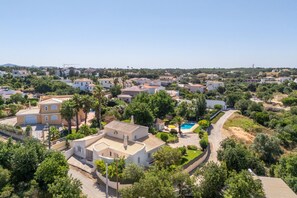Un quartier résidentiel avec des maisons, une piscine et de nombreux espaces verts.