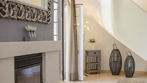 A modern interior with a fireplace, decorative wall, and two lanterns.