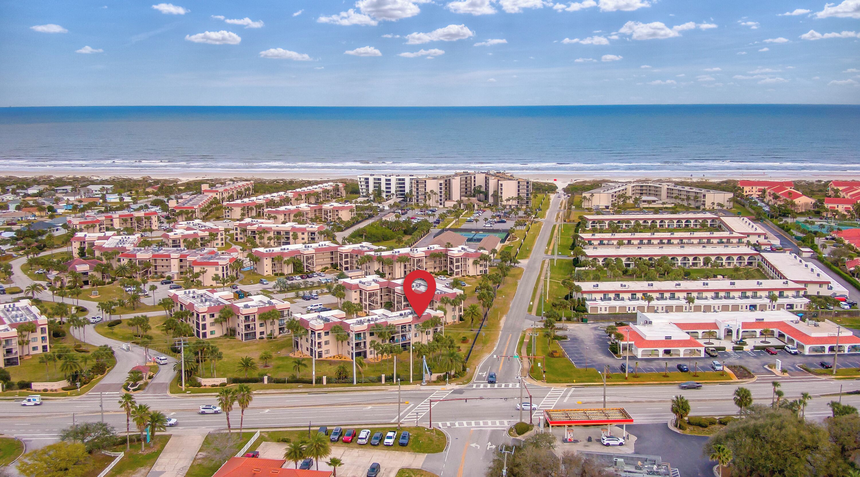 Vista aérea de una zona turística costera con varios edificios hoteleros, carreteras y una playa.