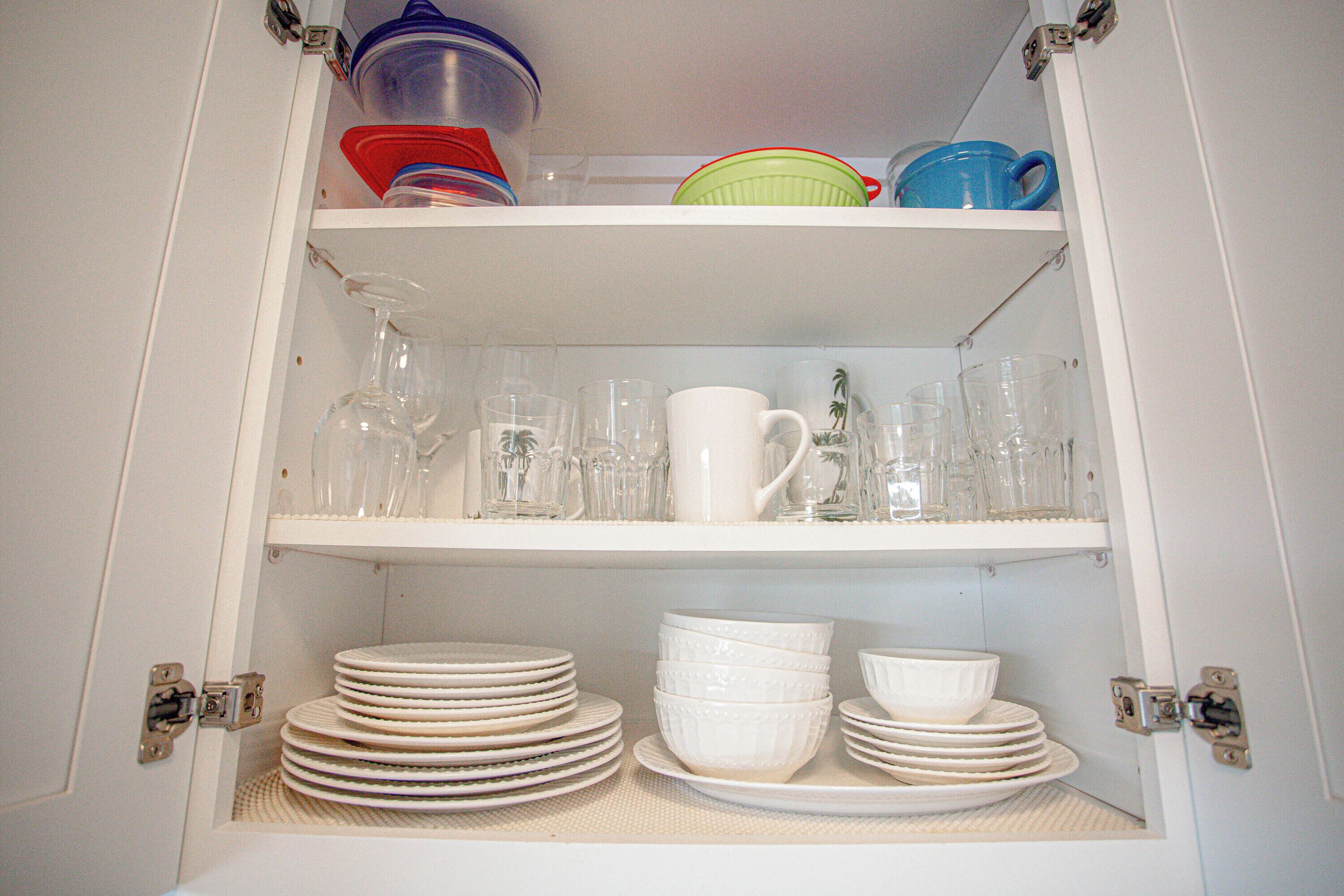 A cabinet with shelves containing various glassware and dishes.