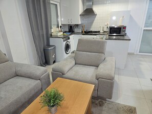 A modern living room with a grey sofa set, a wooden coffee table, and a potted plant. - The Best Condo in Vera with a fantastic View (Vera)