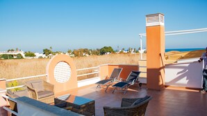 A rooftop terrace with wicker furniture, a view of the sea, and a clear sky. - The Best Condo in Vera with a fantastic View (Vera)