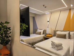 A hotel room with two beds, a bedside table with a lamp, a mirror, and a potted plant. - Panorama Ramsis Hotel & Cafe (Cairo)