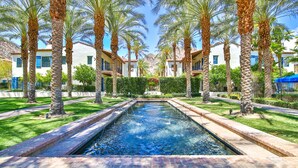 A rectangular pool with a brick border, surrounded by palm trees and a well-maintained lawn. - Poolside! Stunning Villa near sparking pool & large spa, Garage, Pet Friendly! (L62-2) (La Quinta)