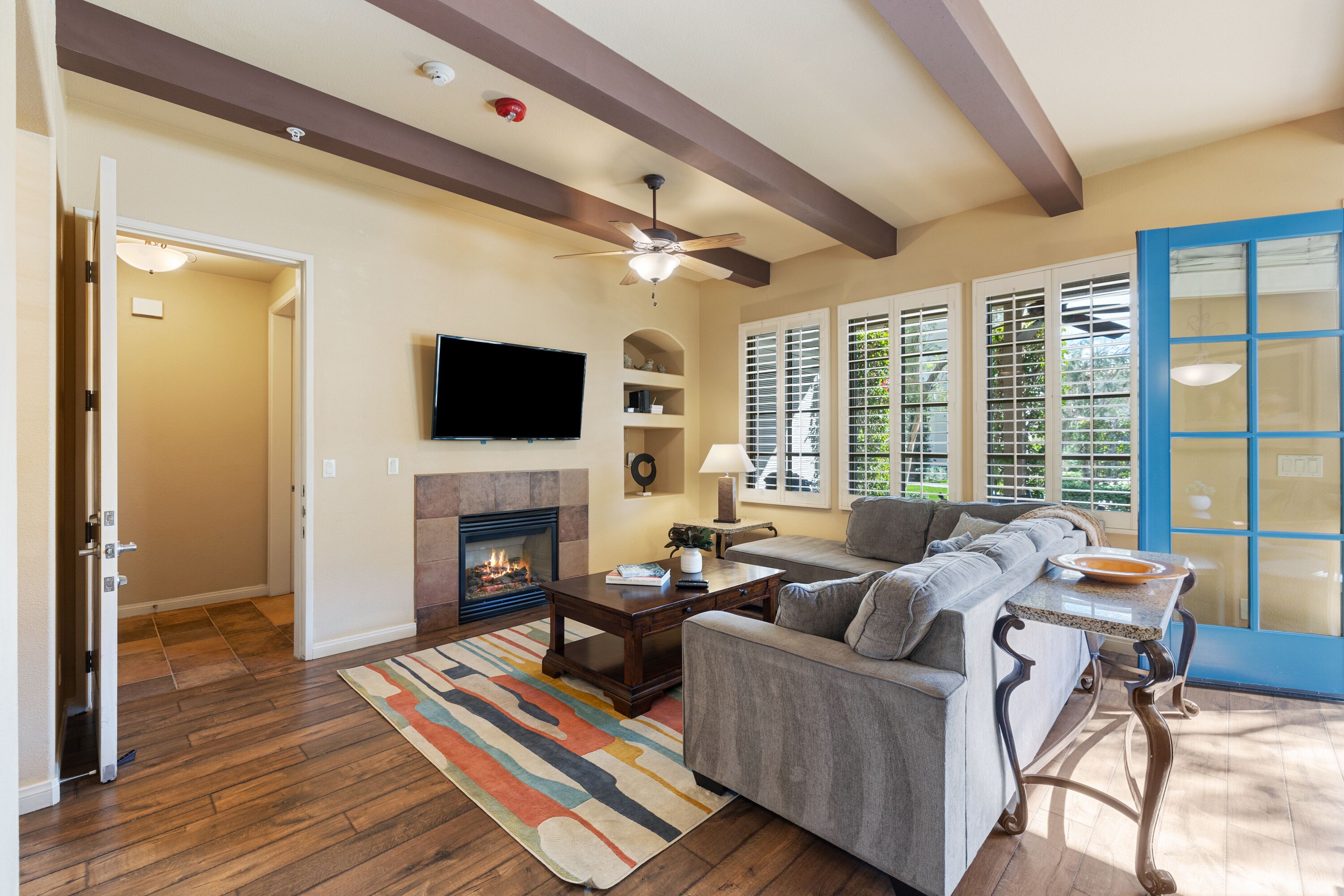 A living room with a fireplace, a sofa, a television, and a dining area with a table and chairs.