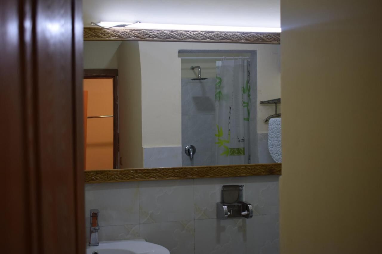 A bathroom with a shower, a toilet, and a sink.