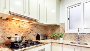 A modern kitchen with white cabinets, a granite countertop, a stove, a toaster, and a sink. - Barcelona Fair 5min walking. TOP 300mb WiFi (L'Hospitalet de Llobregat)