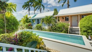 Un área de piscina con vista despejada, rodeada de exuberante follaje y palmeras.