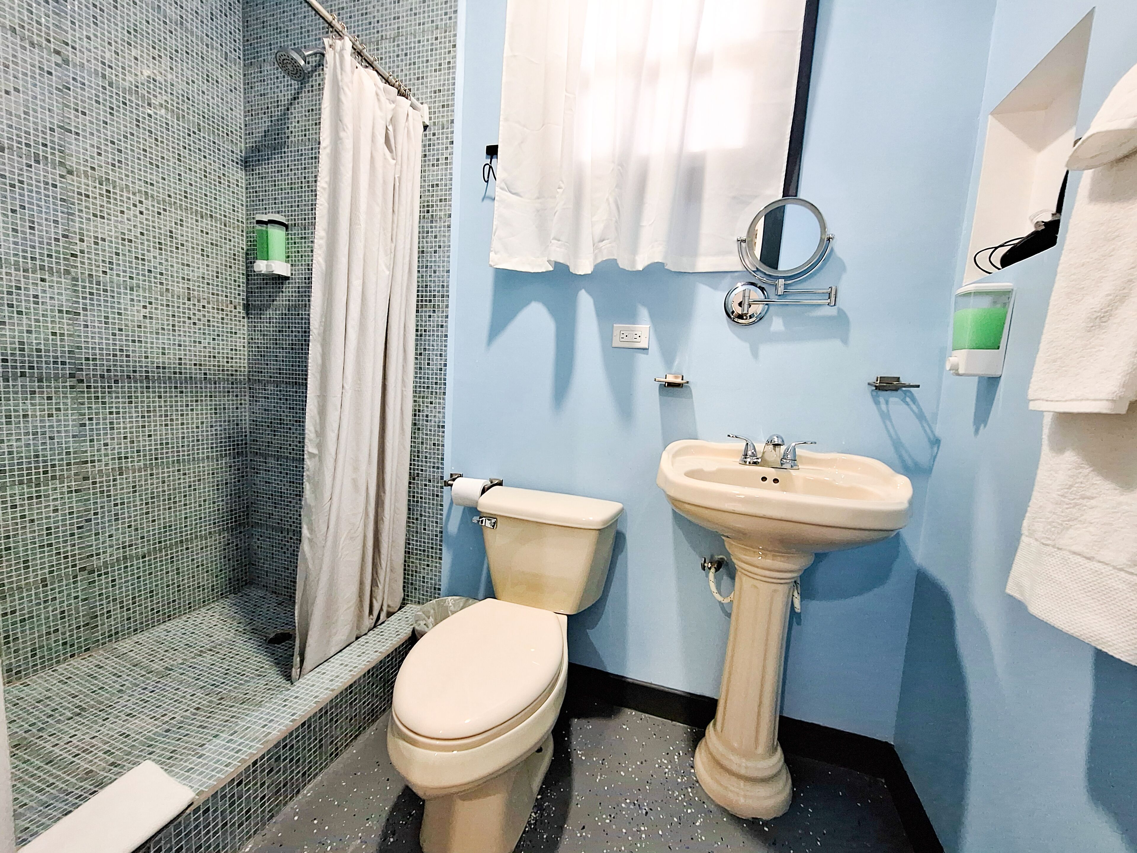 Une salle de bain comprenant des toilettes, un lavabo et un espace douche.