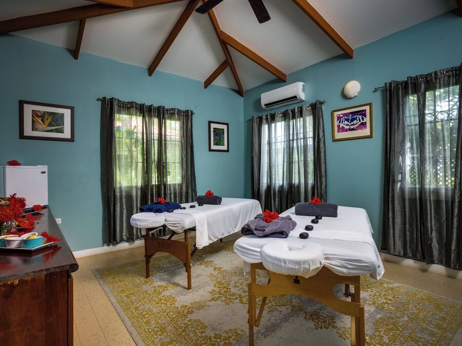 A room with two massage tables, a desk with a computer, and a whiteboard.