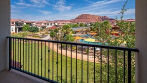 A hotel courtyard with a pool, palm trees, and a mountain backdrop. - Steps to Pool | 2 Family Rooms | Resort Pool Access | Arcadia #7 (Santa Clara)