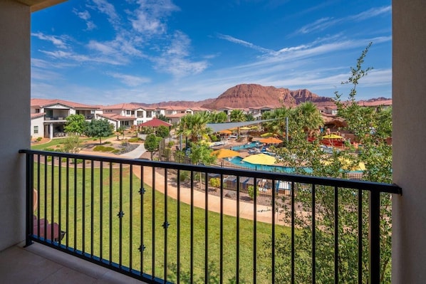 Ein Hotelinnenhof mit Pool, Palmen und einem Berg im Hintergrund.