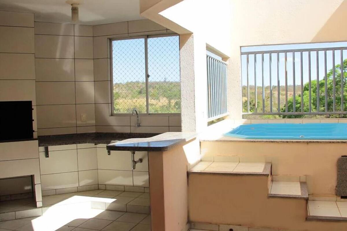 A kitchen with a window, a sink, and a view of a swimming pool.