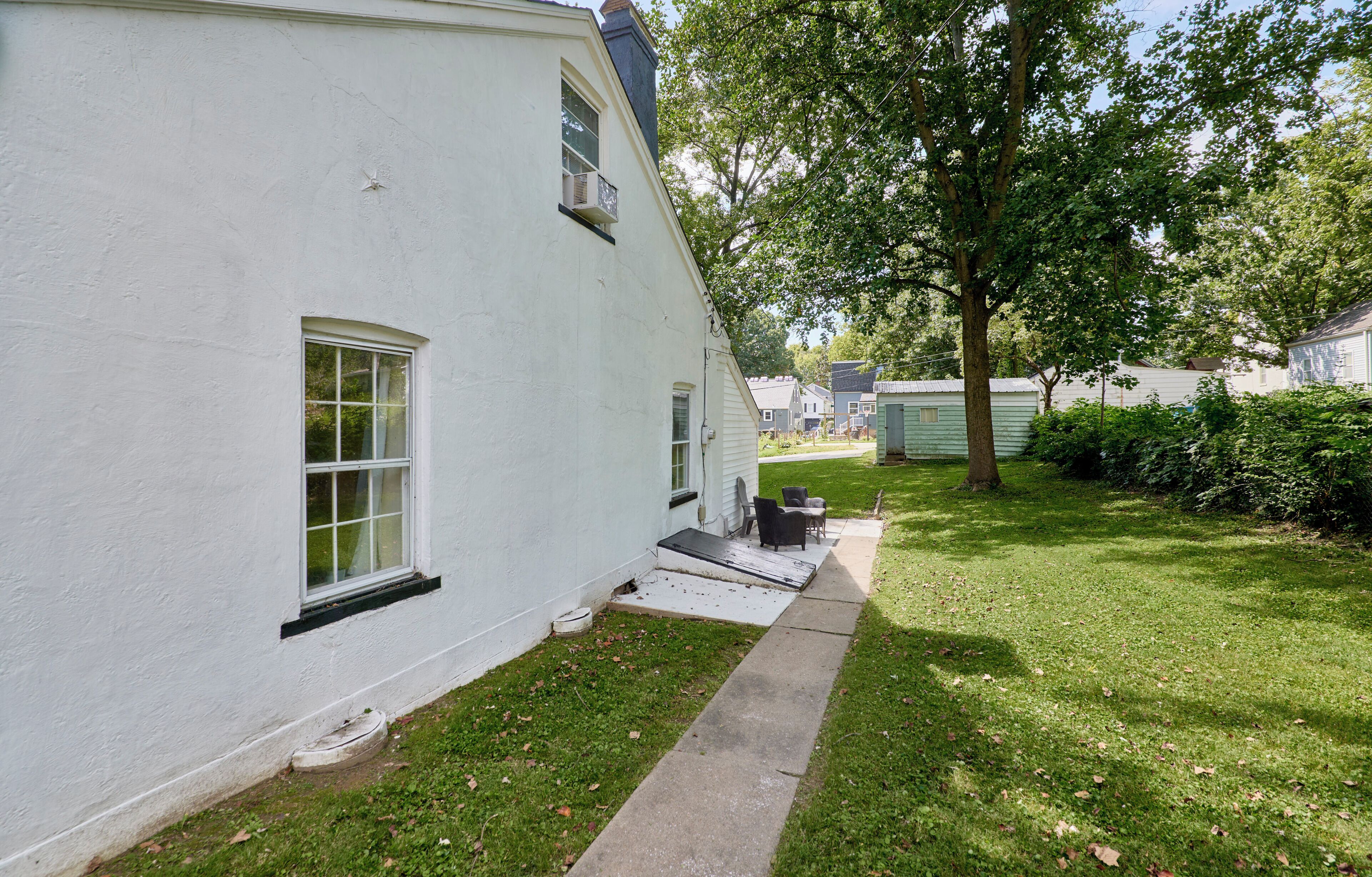 A white house with a small porch and a lawn.