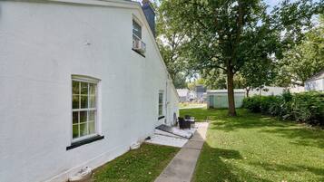 A white house with a small porch and a lawn.