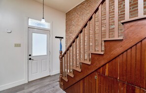 A staircase with wooden steps and a metal railing, leading to a room with a white door and a light fixture above it. - St. Charles 1860's Gem - Sleeps 6! (St Charles)