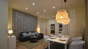 Un salon moderne comprenant un canapé, une table basse et une table à manger avec des chaises.