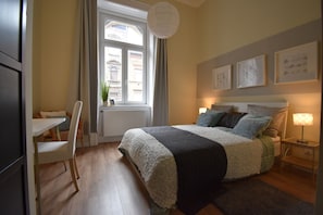 A bedroom with a bed, bedside tables, a window, and a chair.