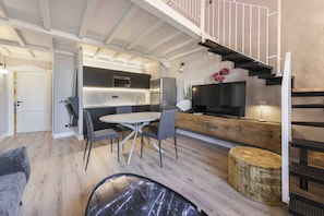 Une cuisine moderne avec un coin repas, un escalier et un espace de vie.