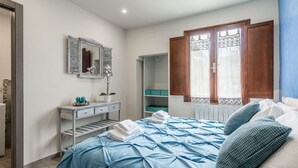 A bedroom with a bed, a dresser, a mirror, and a window with curtains. - Apartment Dreamy Guelfa by Mmega (Firenze)