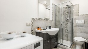 A modern bathroom with a glass-enclosed shower, a white sink, and a large mirror. - Apartment Dreamy Guelfa by Mmega (Firenze)