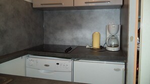 A compact kitchen with a Bosch coffee maker, a dishwasher, and a small countertop. - apartments - 2 rooms - 5/6 persons (Les Belleville)