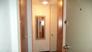 A narrow hallway with wooden doors and a mirror on the wall. - apartments - 2 rooms - 5/6 persons (Les Belleville)