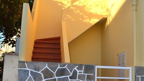 Ein Gebäude mit einer Steinmauer, einer Holztreppe und einem Metallgitter.