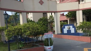 A building entrance with a sign indicating a parking area for handicapped individuals. - Beach apartment in Enseada, in a gated community, with garden and balcony. (Guaruja)
