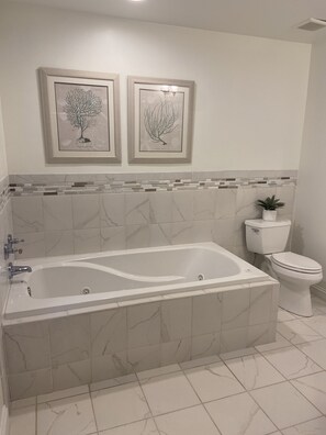 Tina con regadera, tina de hidromasaje, secadora de cabello, toallas 