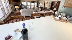 A cozy living room with a fireplace, a dining area with a table and chairs, and a kitchen area with a countertop.