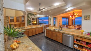 A modern kitchen with granite countertops, wooden cabinets, and a built-in dishwasher.