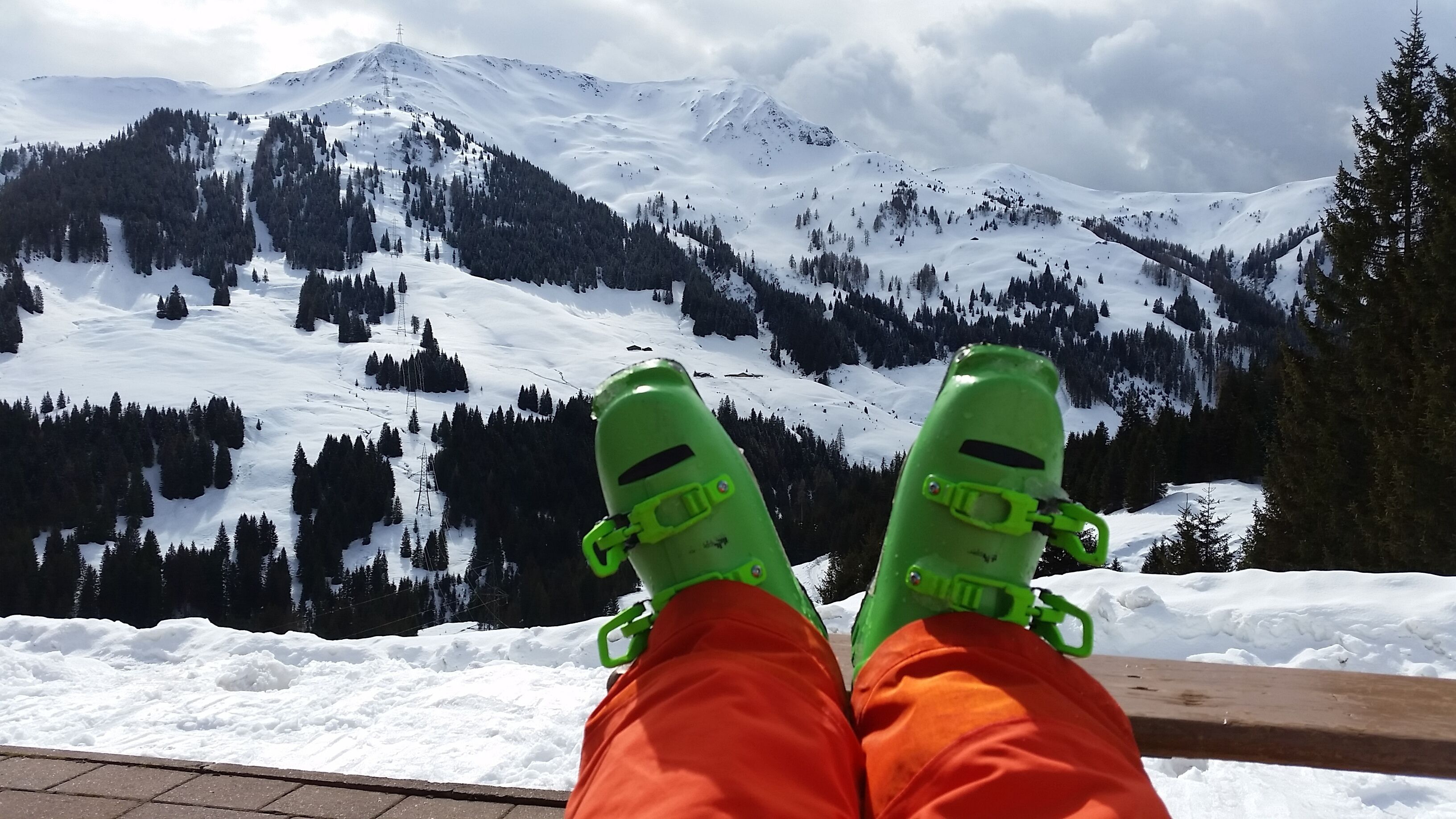 A person sitting with snow-covered mountains in the background.