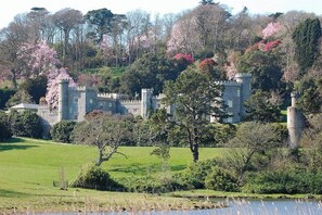 A castle with a tower, surrounded by lush greenery and trees. - Historic Chapel, Great Facilities nr Beaches (St Austell)