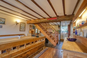 A rustic kitchen with wooden beams, a wooden bench, and a staircase. - Historic Chapel, Great Facilities nr Beaches (St Austell)