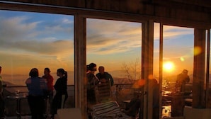 A group of people on a terrace with a view of the sunset and mountains. - Ski Chalet Rental in Chile (Santiago)