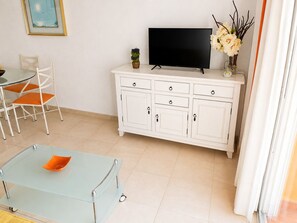 A living room with a glass coffee table, white cabinet, flat-screen TV, and orange chairs. - Calpe: apartment/ flat - CALPE (Calpe)