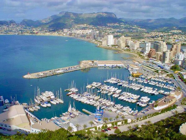A marina with numerous boats docked, surrounded by a coastal cityscape with buildings and mountains in the background. - Calpe: apartment/ flat - CALPE (Calpe)