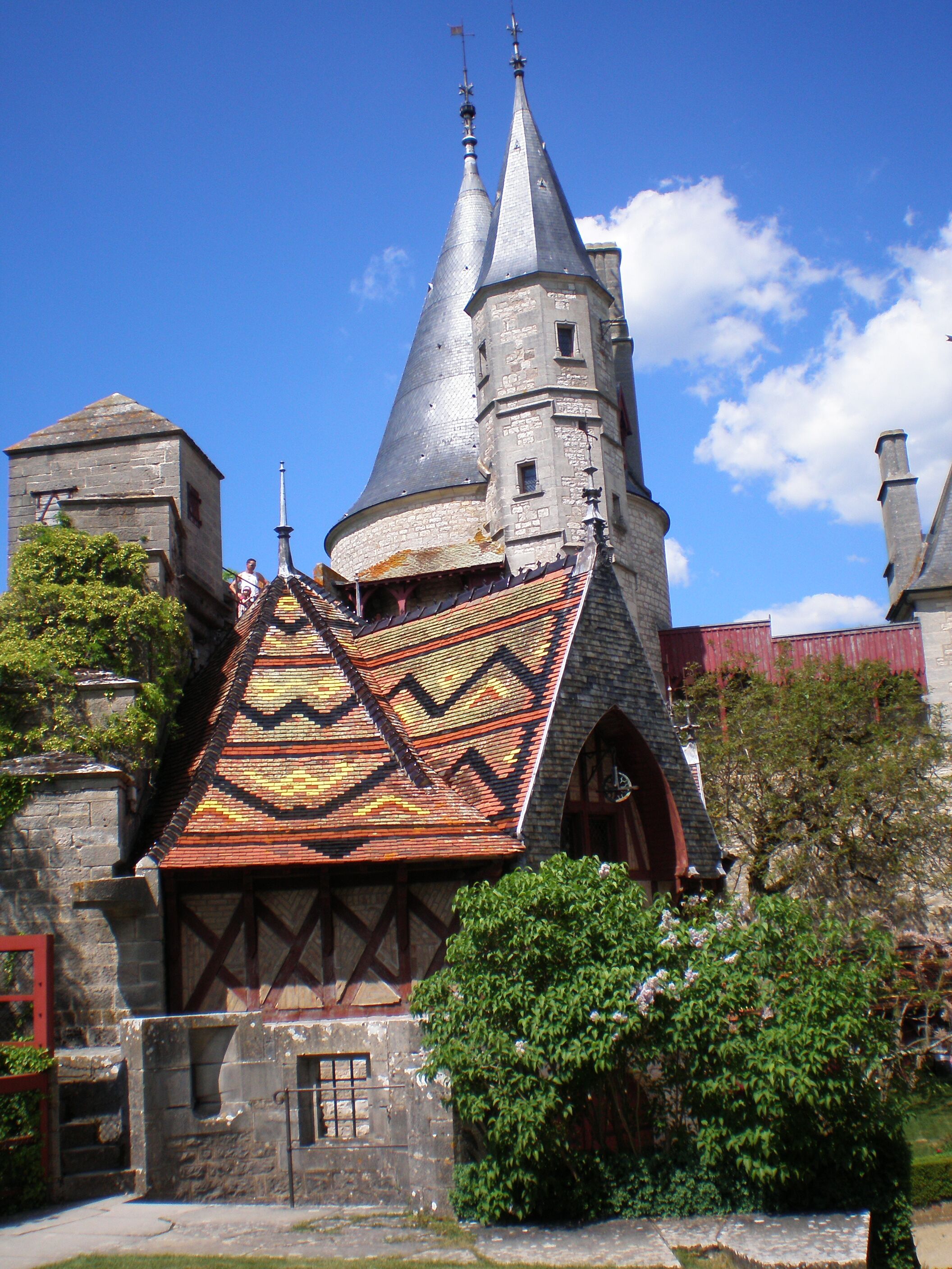 A historic building with a distinctive tiled roof and two spires.
