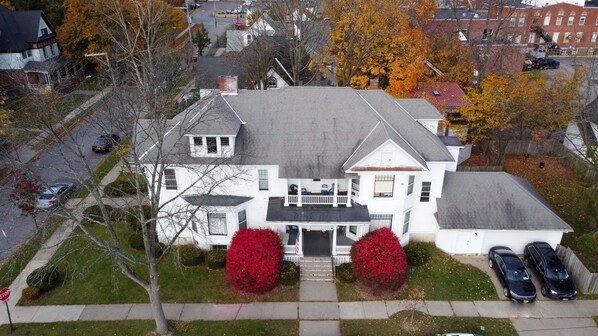 A large, two-story house with a front porch, a garage, and a driveway with cars parked. - 1st Class Rentals Munson Manor VII at Watkins Avenue (Oneonta)