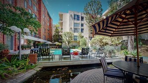 A courtyard with a swimming pool, outdoor seating, and a small pond. - Centrally Located Modern Luxury, Walking Distance to UCLA, Westwood (Los Angeles)