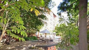 A courtyard with a fountain, outdoor seating, and lush greenery. - Centrally Located Modern Luxury, Walking Distance to UCLA, Westwood (Los Angeles)