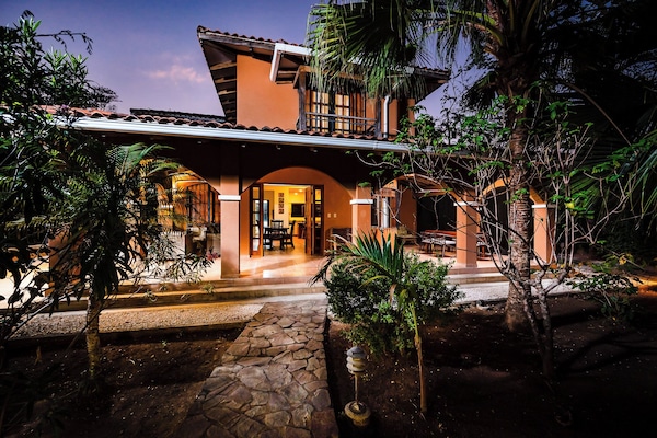 Front of villa from garden walkway at twilight