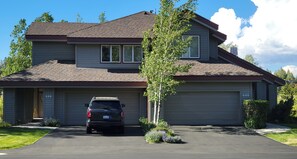 A two-story house with a garage, a driveway, and a tree in front. - Snowcreek Resort Vacation Rental 506 (Mammoth Lakes)