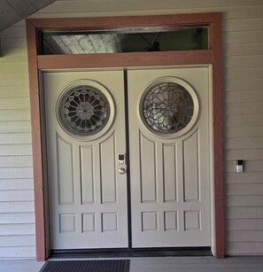 A double door with a circular stained glass window on each door. - Snowcreek Resort Vacation Rental 506 (Mammoth Lakes)
