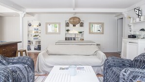 Una sala de estar con un sofá, una mesa de centro y una estantería.