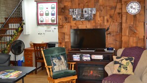 Una sala de estar con chimenea, televisor y una pared de madera.