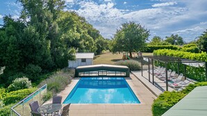 A swimming pool with a glass enclosure, surrounded by greenery and a pergola with lounge chairs. - AGRANGESUD Luxury Dordogne Villas, overlooking Chat Vigiers golf, 25min Bergerac (Razac-De-Saussignac)